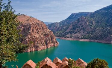 Scenic lake surrounded by red mountains and resort rooftops