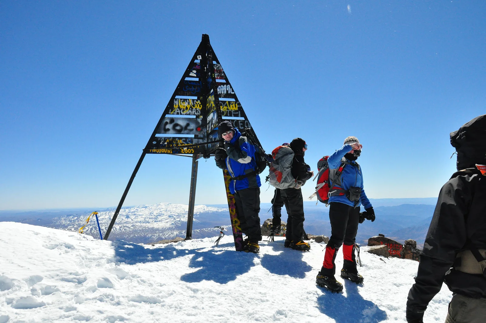 Group of mountaineers reaching snowy summit