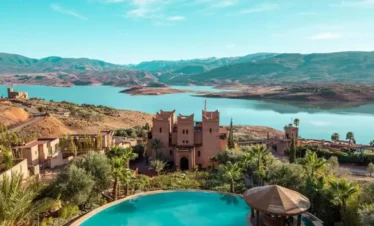 Traditional Moroccan architecture with a scenic pool and hills