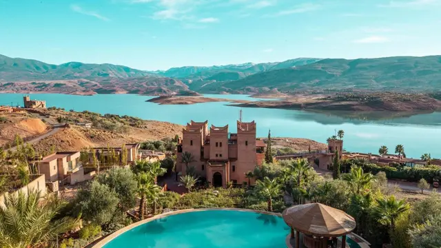 Traditional Moroccan architecture with a scenic pool and hills