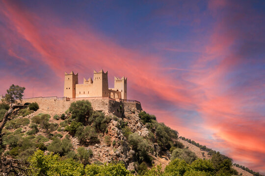 Ancient Moroccan castle glowing under a pink-orange sky