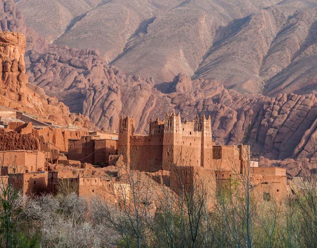 Hikers walking through water in a Moroccan gorge