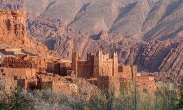 Hikers walking through water in a Moroccan gorge