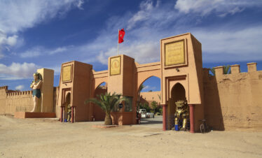 Moroccan-style gate adorned with flags and traditional architecture