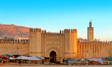 Massive clay ramparts and gate leading into a historic Moroccan city