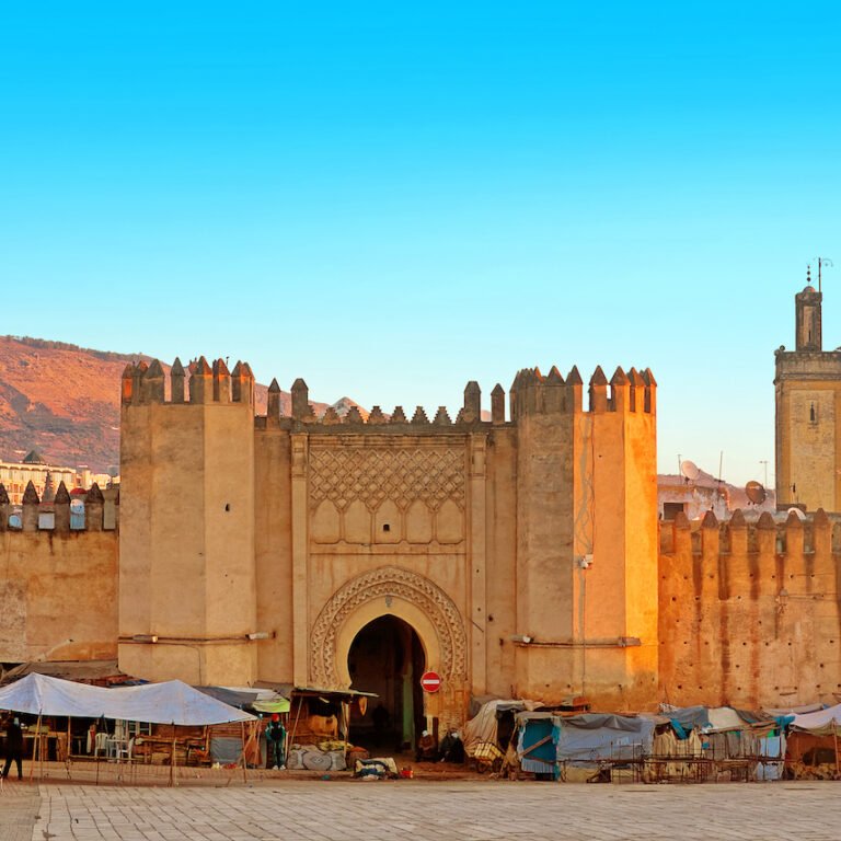 Massive clay ramparts and gate leading into a historic Moroccan city