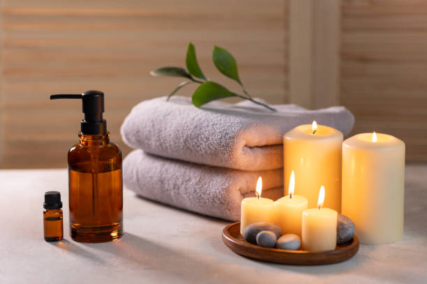 Towel, oil bottles and candle in spa scene