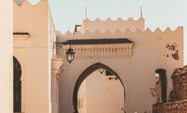 Woman in white dress standing in a blue Chefchaouen alleyway