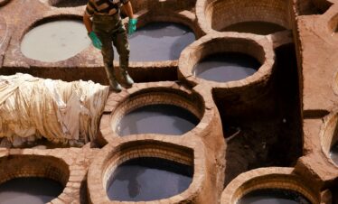 Moroccan man walking down a bright blue street in Chefchaouen