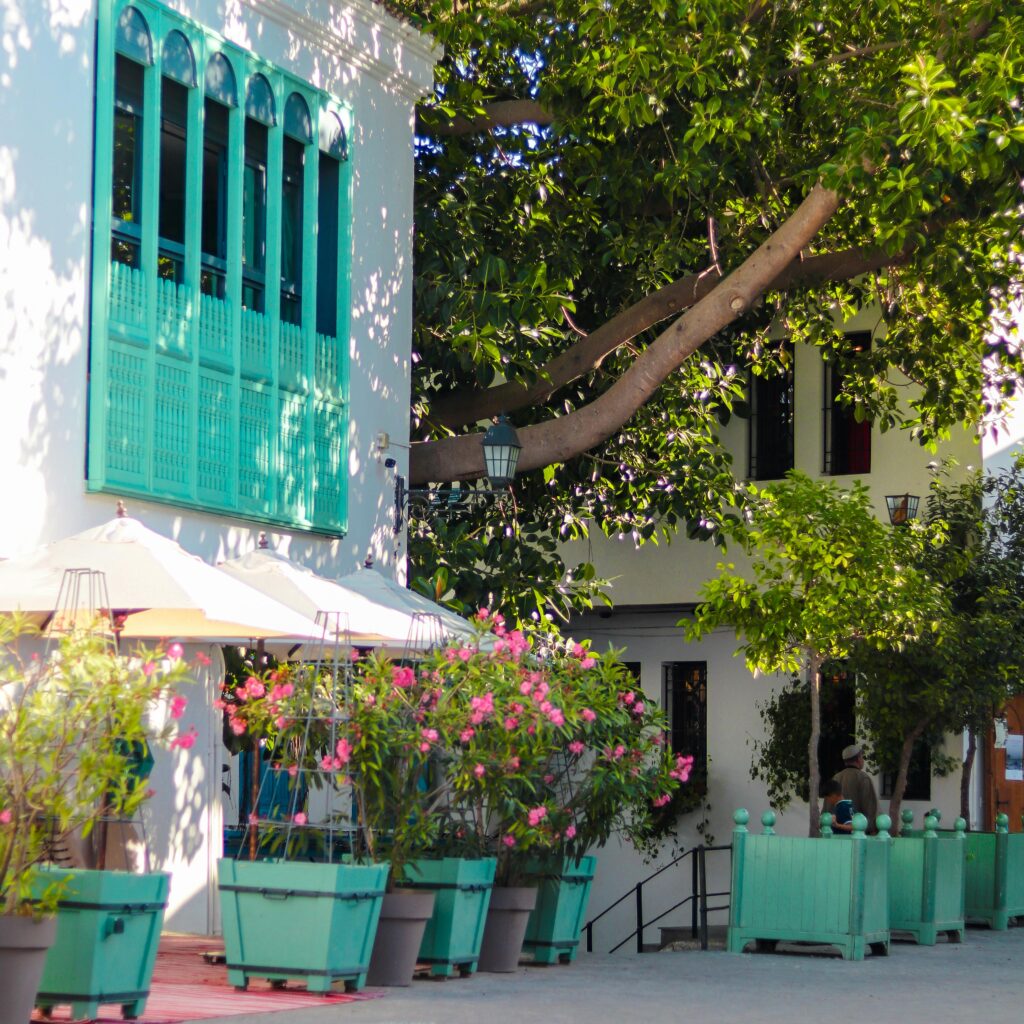 Colorful café with green shutters and floral decor in Morocco