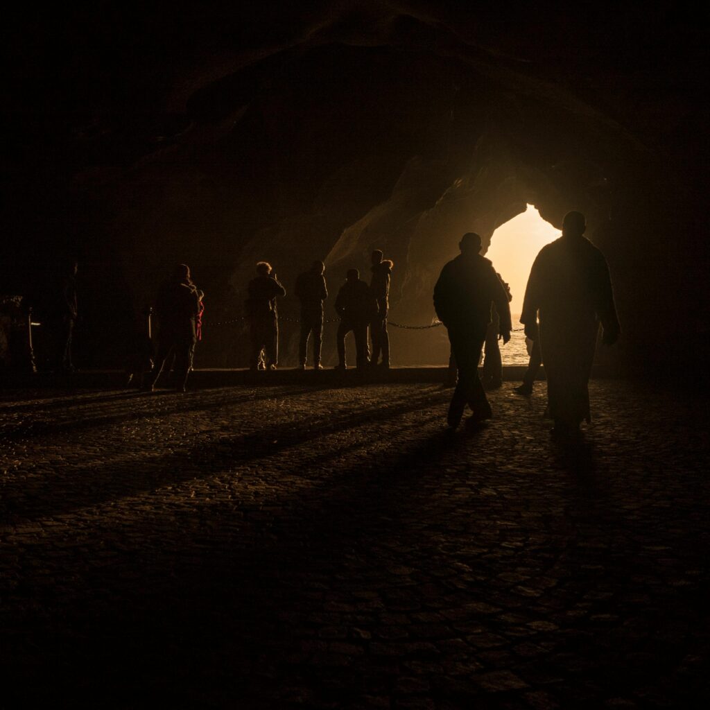 Silhouettes walking through arched tunnel in Morocco