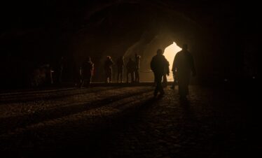 Silhouettes walking through arched tunnel in Morocco