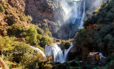Cascading waterfall surrounded by rocky cliffs and trees
