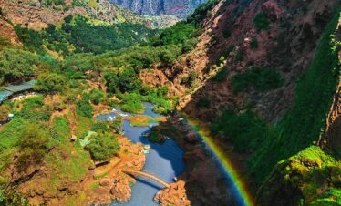 Lush valley with river and rainbow