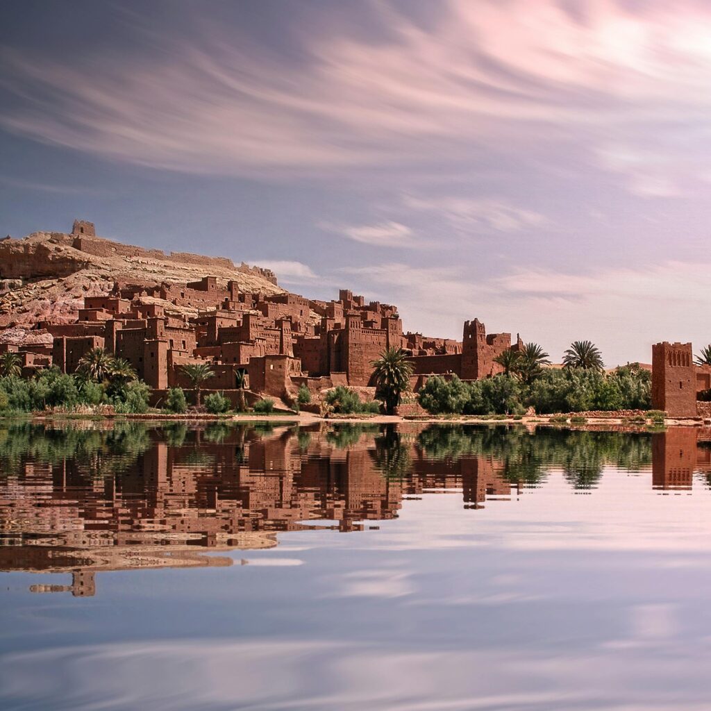 Moroccan kasbah mirrored in still waters during sunset