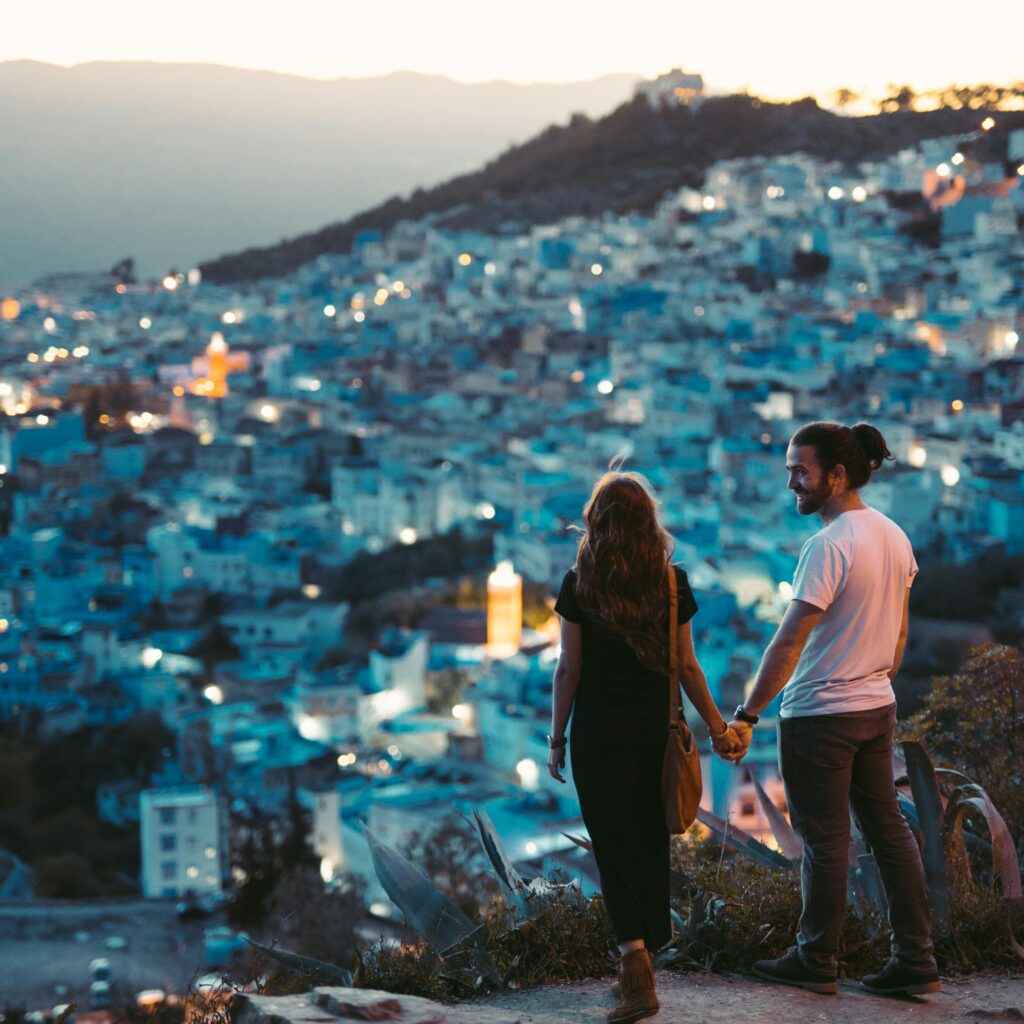 Couple walking hand-in-hand in Chefchaouen’s blue medina