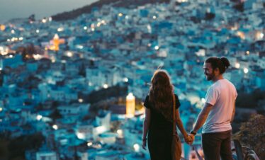 Couple walking hand-in-hand in Chefchaouen’s blue medina
