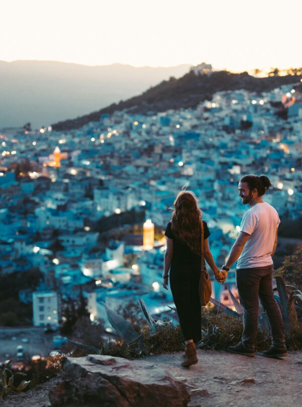 Couple walking hand-in-hand in Chefchaouen’s blue medina
