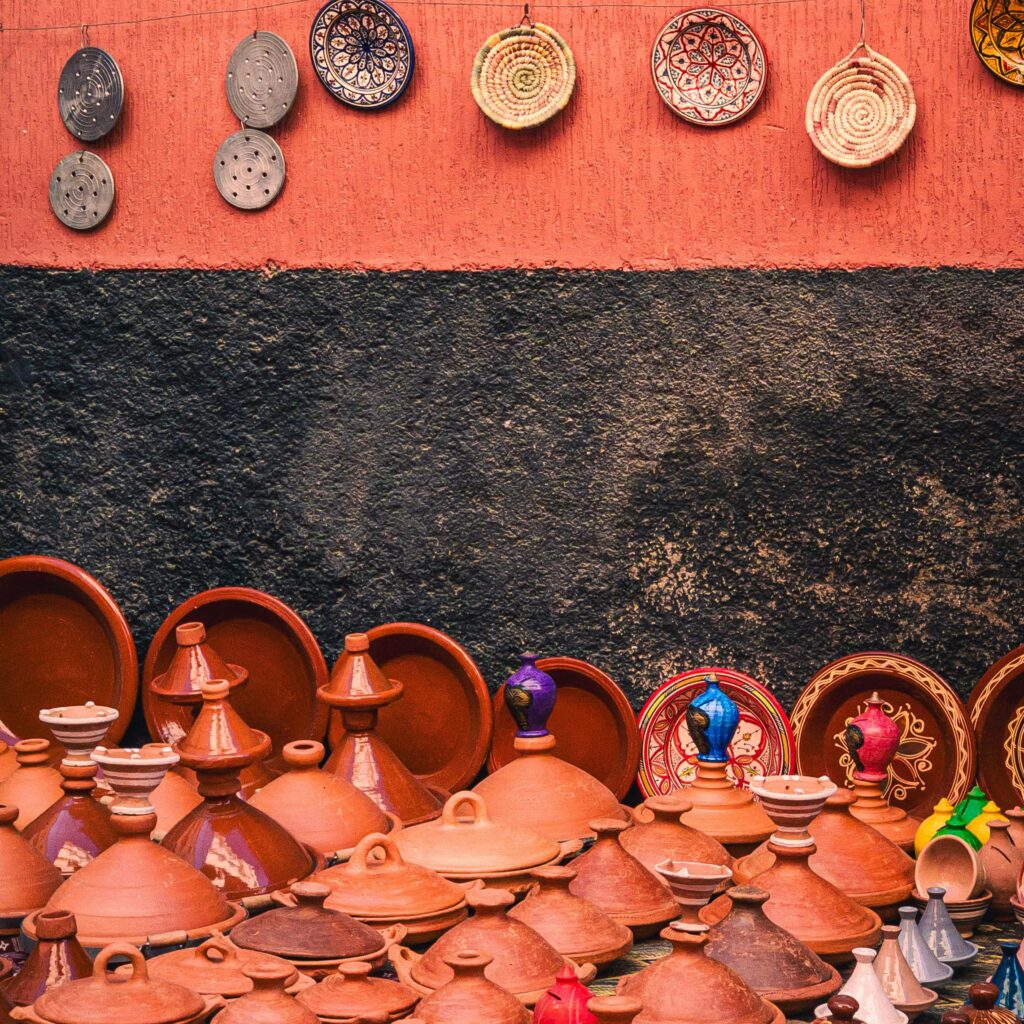 Terracotta pots and dishes arranged on a red wall