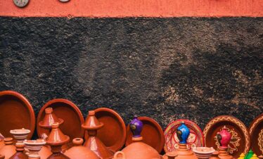 Terracotta pots and dishes arranged on a red wall