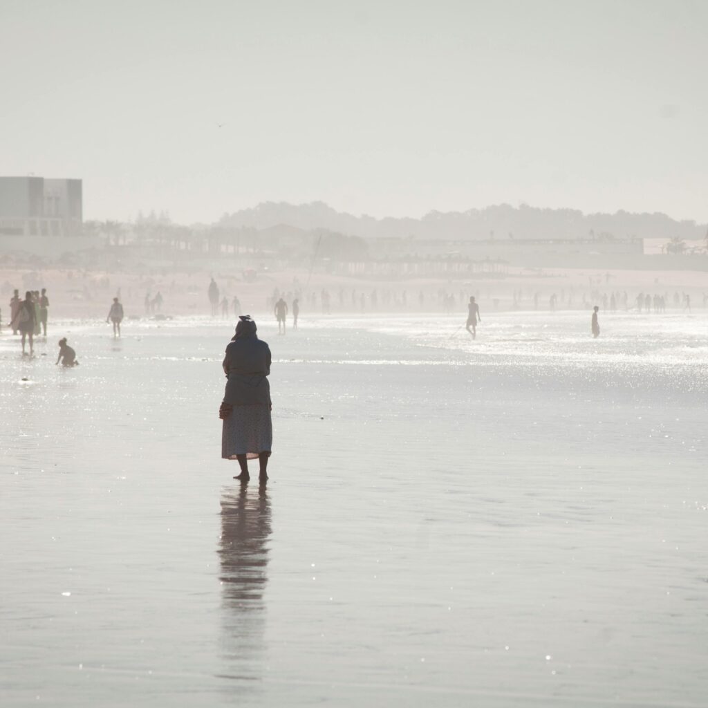 Lone figure walking along a foggy beach or tidal flat