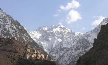 Tree-lined valley with snowy peaks