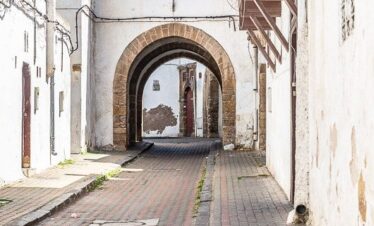 Narrow white alley with stone floor