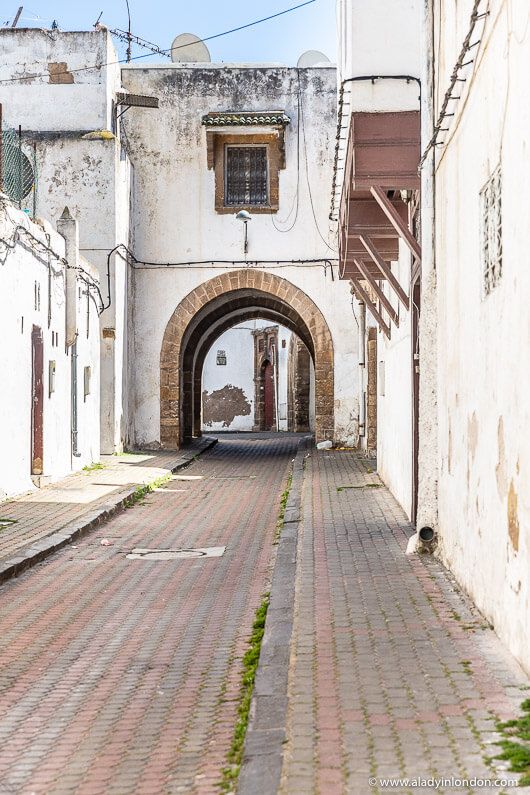 Narrow white alley with stone floor