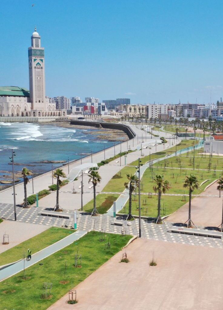 Curved coastal walkway near beach and towers