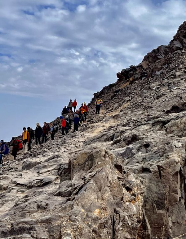 Hikers climbing a rocky trail