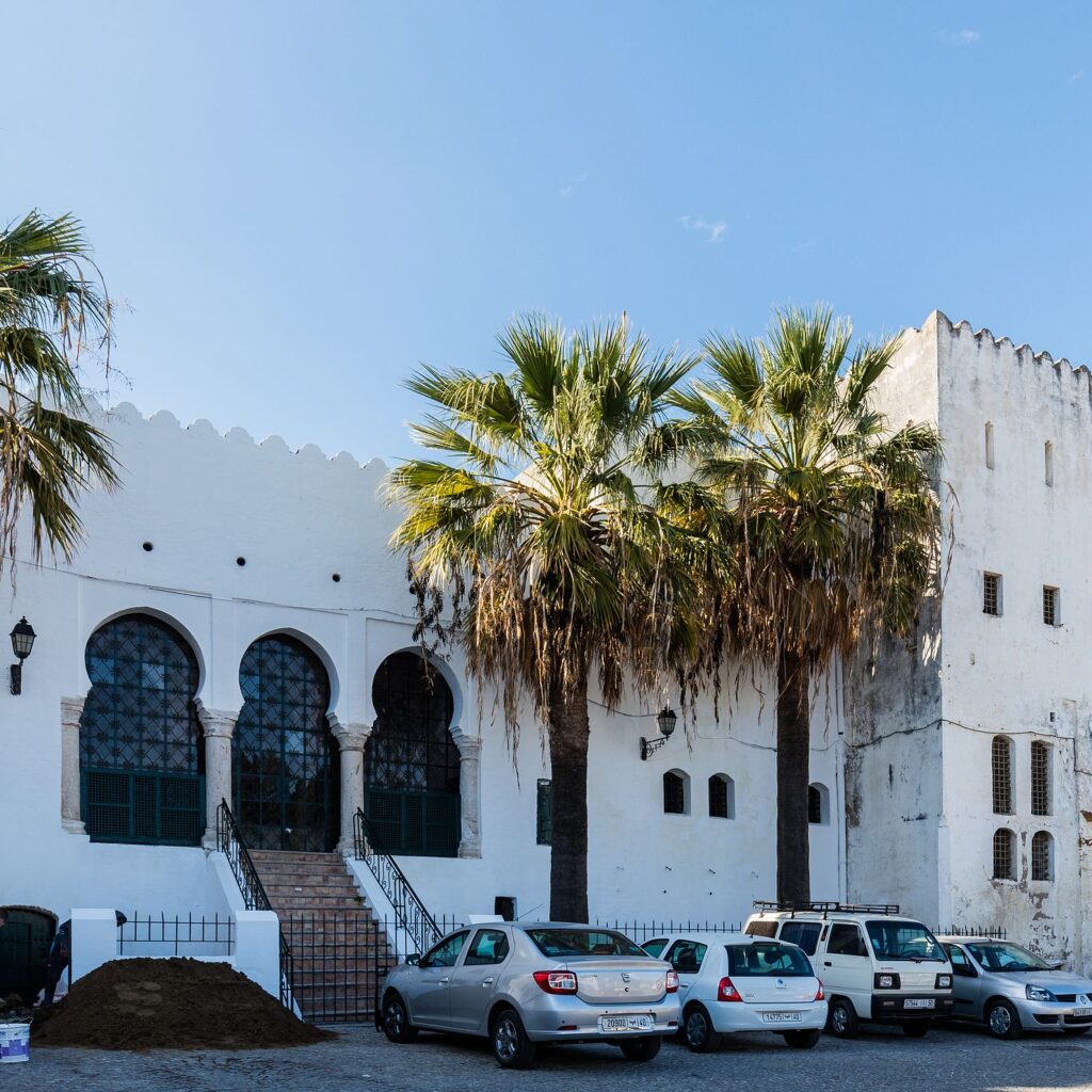 White Moroccan house with palm trees in front