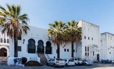White Moroccan house with palm trees in front