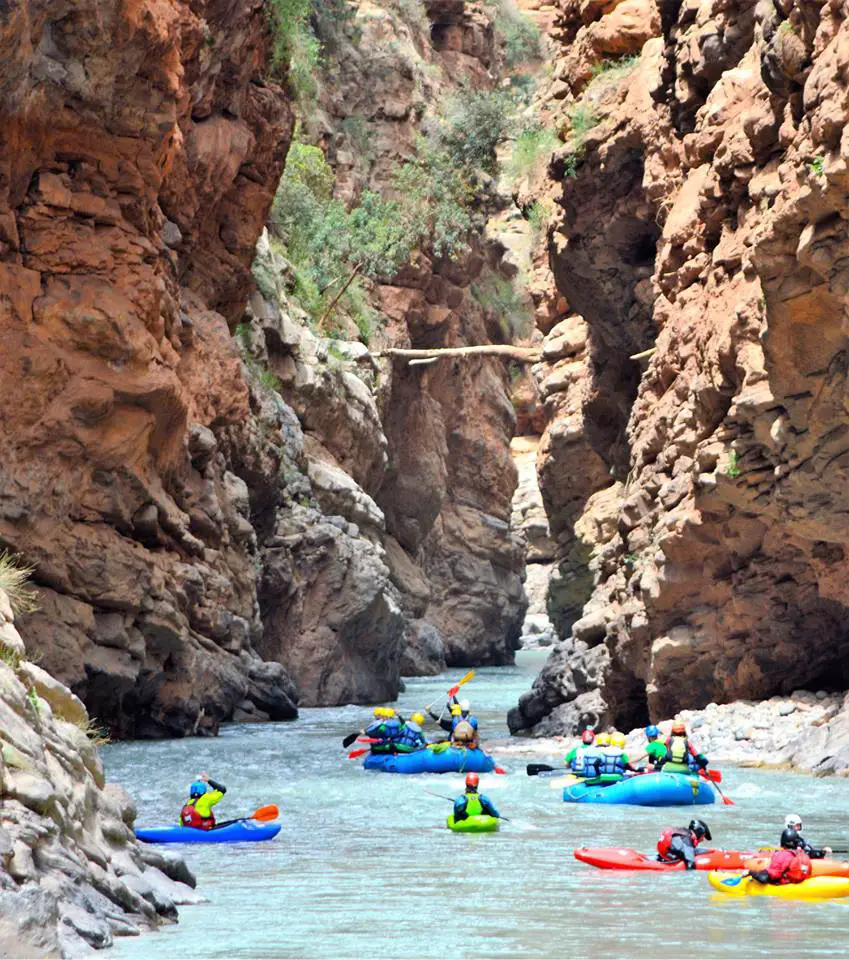 Tourists kayaking through a rocky river canyon in Morocco