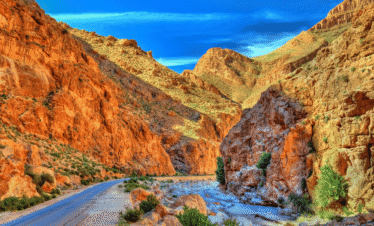 Narrow valley with rugged red rock formations in Morocco.