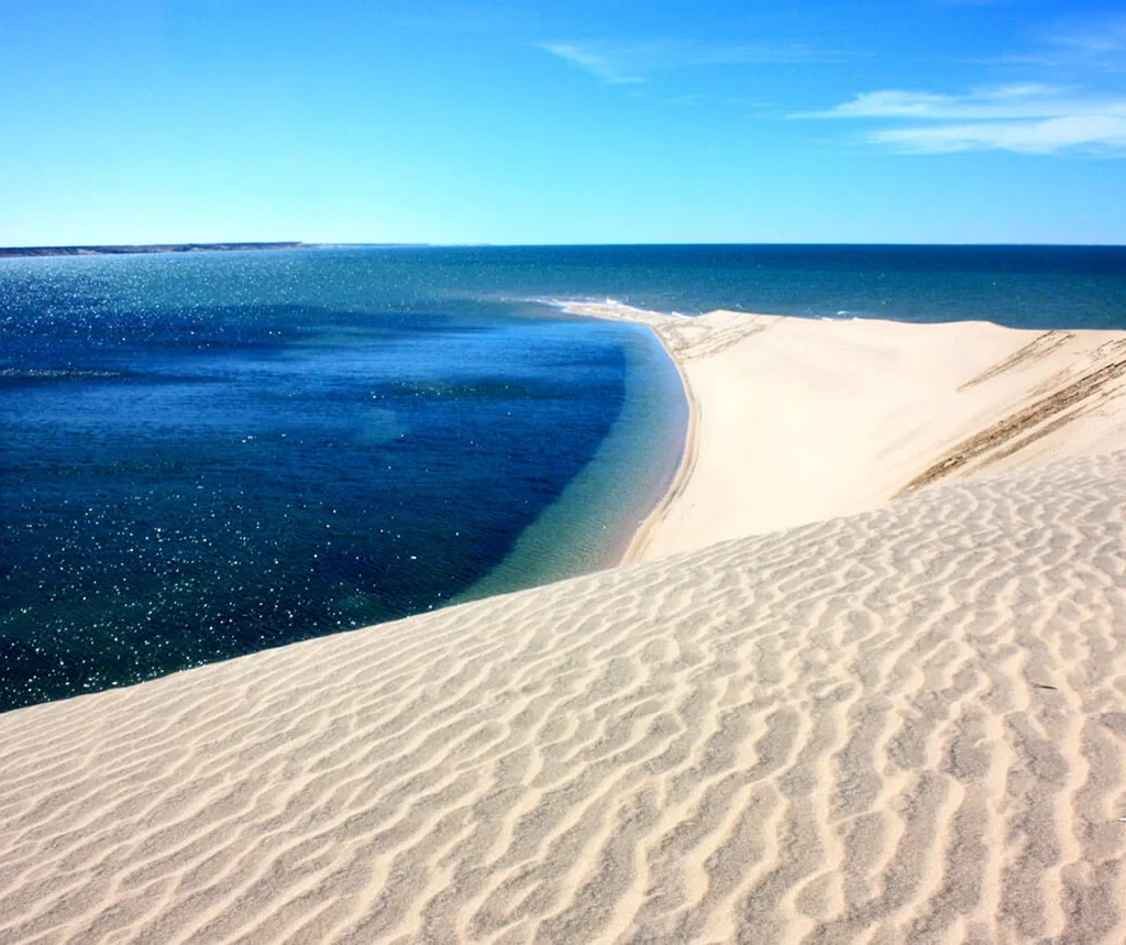 Natural sandbar surrounded by blue water