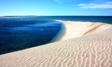 Natural sandbar surrounded by blue water