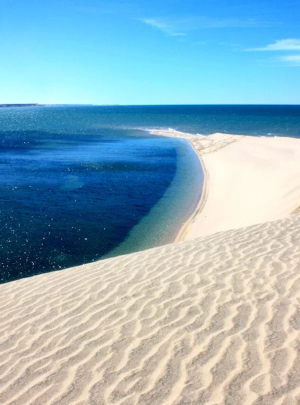 Natural sandbar surrounded by blue water