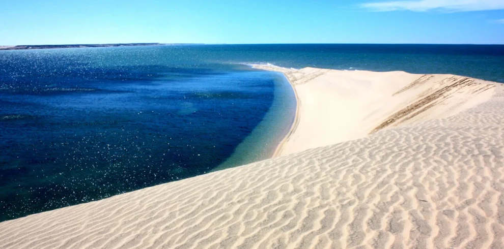 Natural sandbar surrounded by blue water