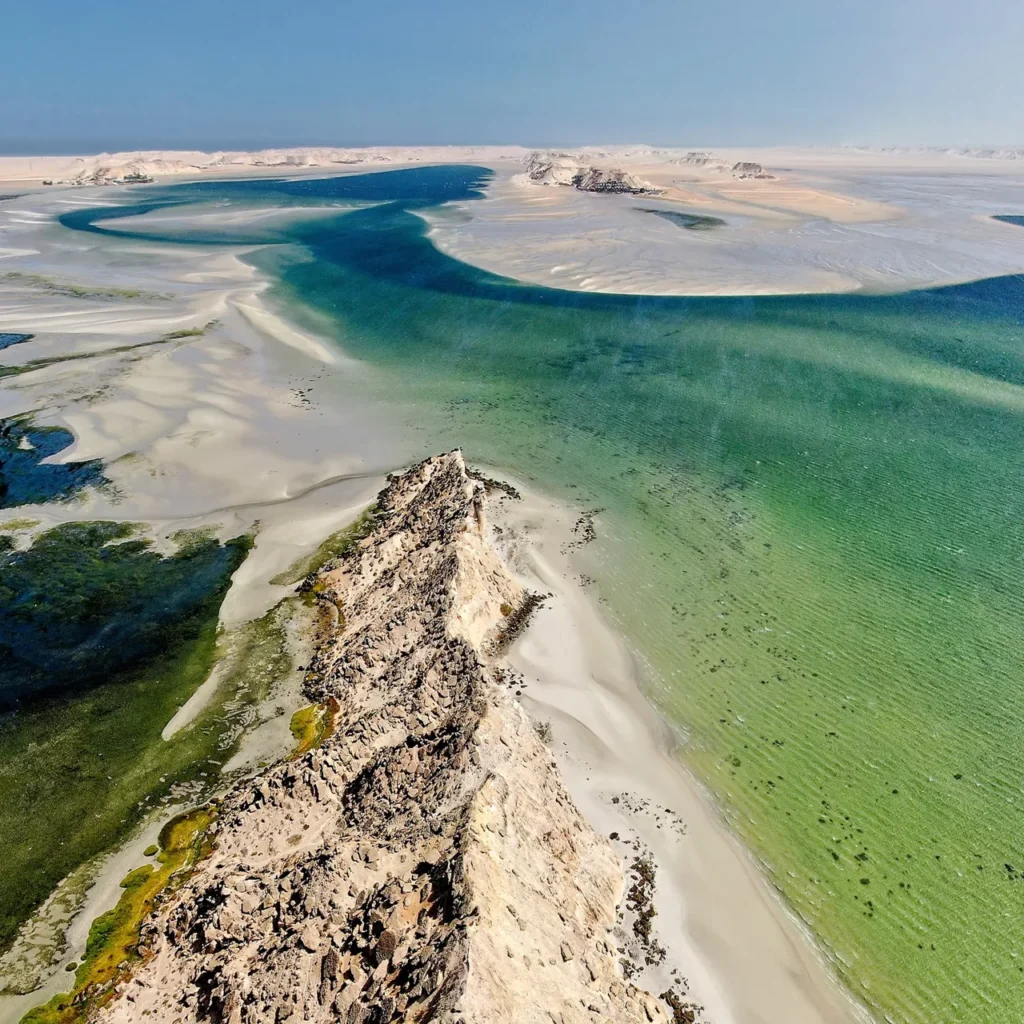Golden sand dunes fading into turquoise ocean