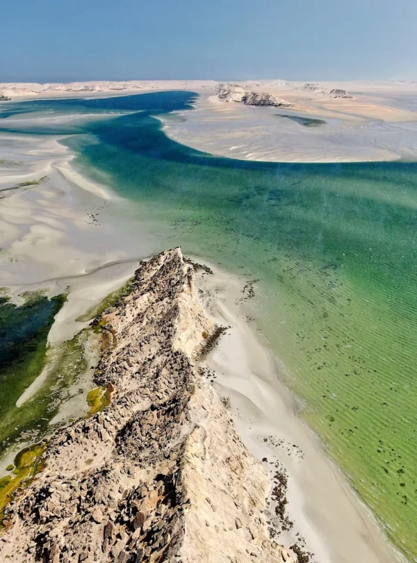 Golden sand dunes fading into turquoise ocean