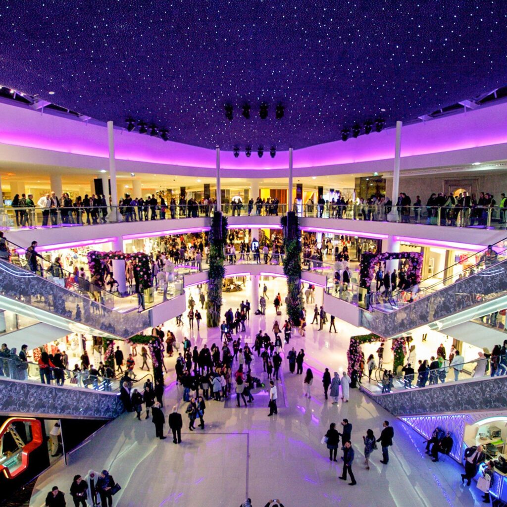 Purple ceiling lights over shopping crowds