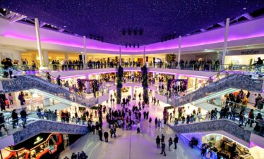 Purple ceiling lights over shopping crowds