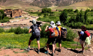 Two hikers walking on a rugged trail in the Atlas foothills.