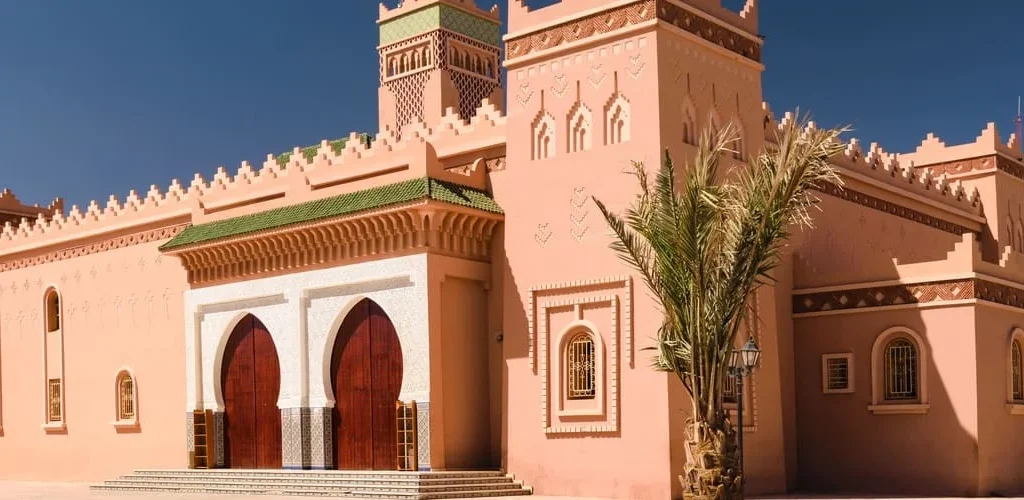 Pink mosque with palm trees and minaret
