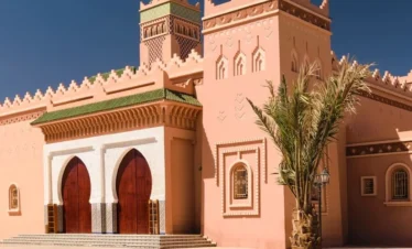 Pink mosque with palm trees and minaret