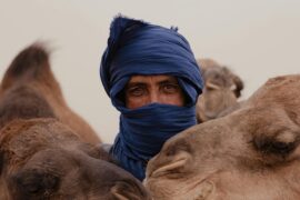 Home - Hayya Morocco Man with two camels in traditional attire