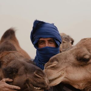 Man with two camels in traditional attire