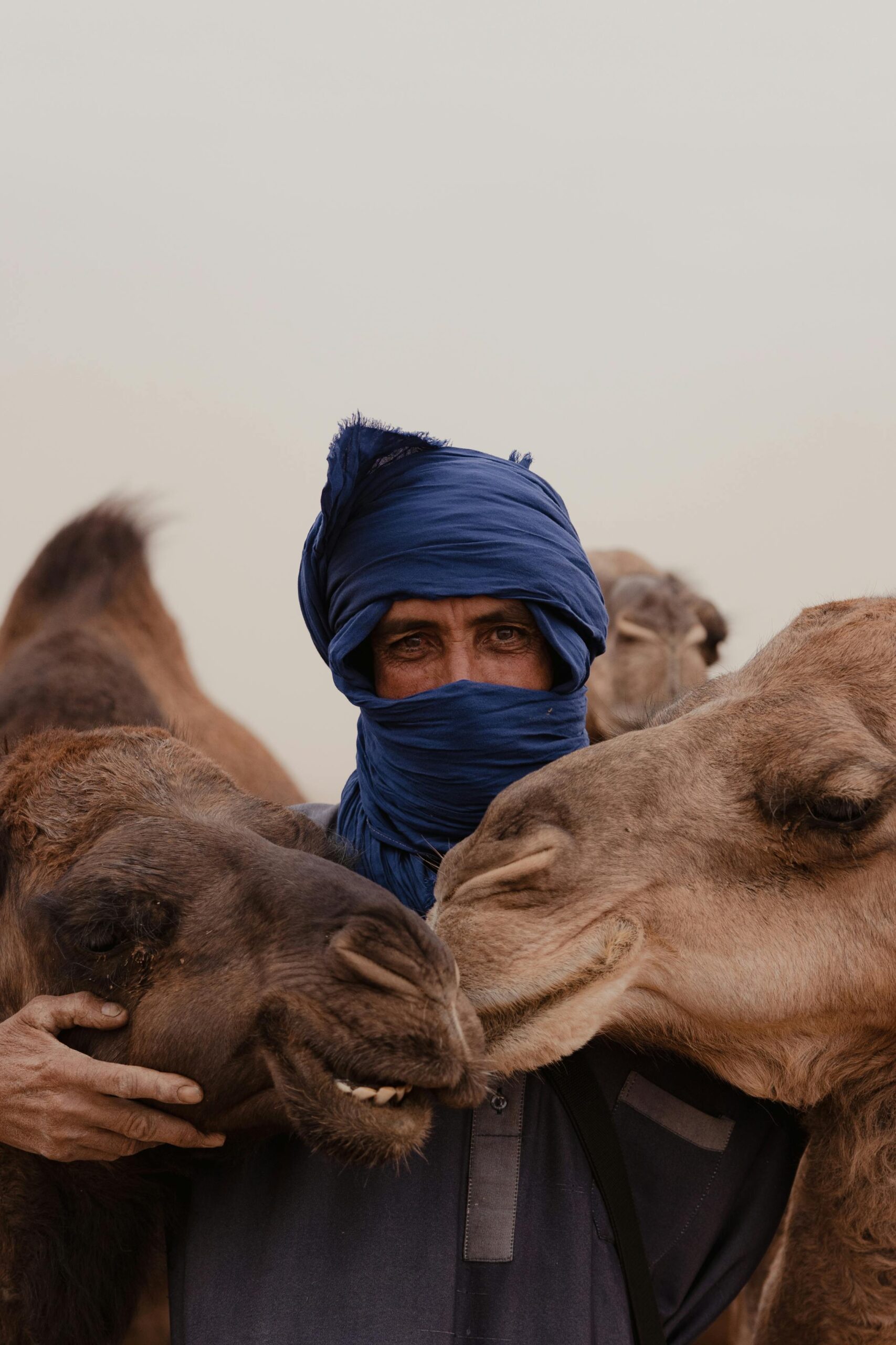 Man with two camels in traditional attire