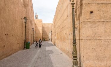Thick kasbah walls with lamp-lit alley