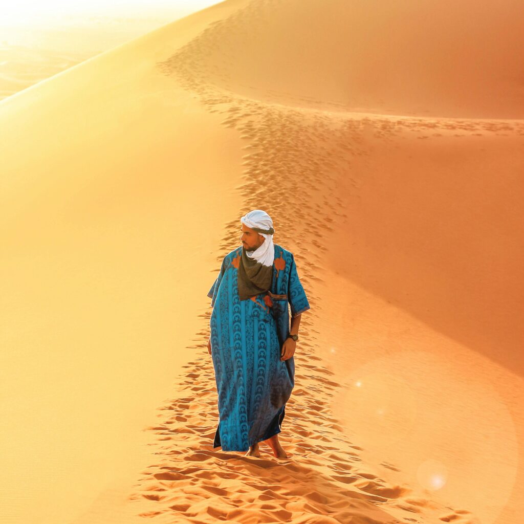Lone figure walking during desert sunset